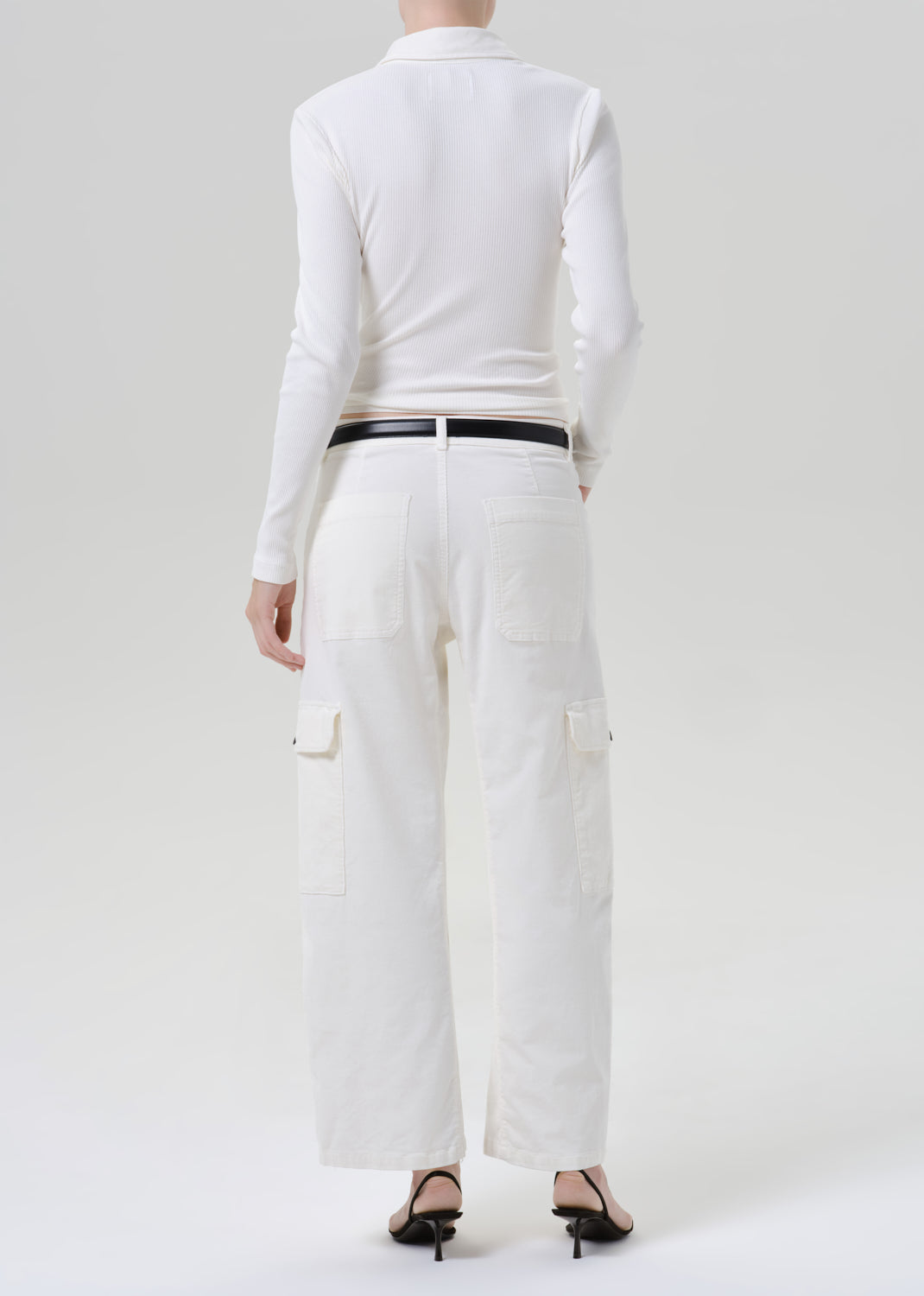Person wearing white outfit on a grey background