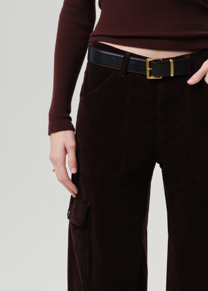 Person wearing a maroon sweater and dark brown cargo pants with a black belt.