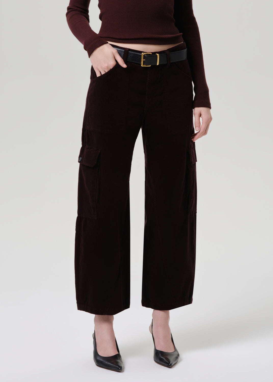 Person wearing brown cargo pants and a matching top on a grey background