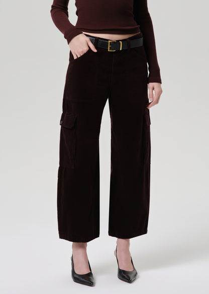 Person wearing brown cargo pants and a matching top on a grey background