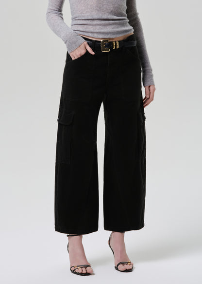 Person wearing black wide-leg pants and a grey sweater on a white background
