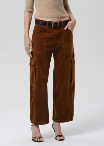 Brown corduroy cargo pants worn by a person on a grey background