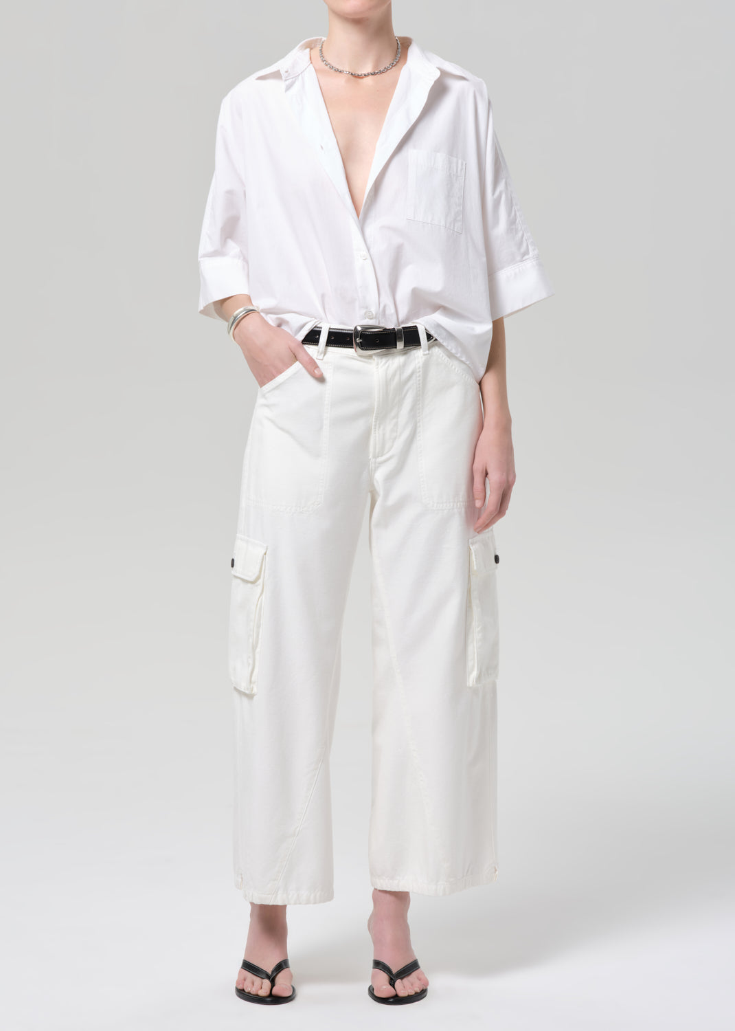 Person wearing a white shirt and wide-leg pants on a plain background