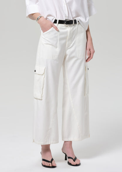 Person wearing a white outfit with wide-leg pants on a plain background
