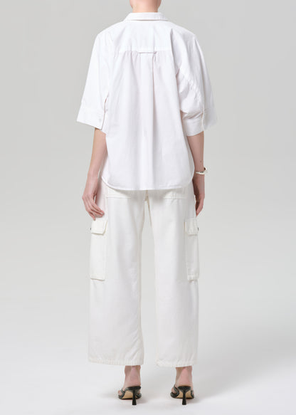 Person wearing a white outfit on a plain background