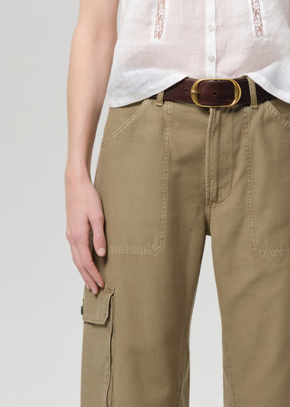 Person wearing beige cargo pants with a white shirt on a light gray background