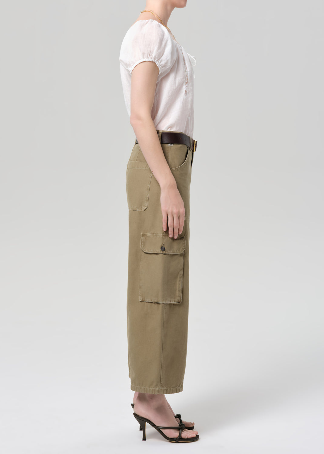 Person wearing a white top and beige cargo pants on a plain background