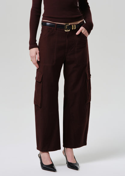 Person wearing brown cargo pants with a belt on a grey background