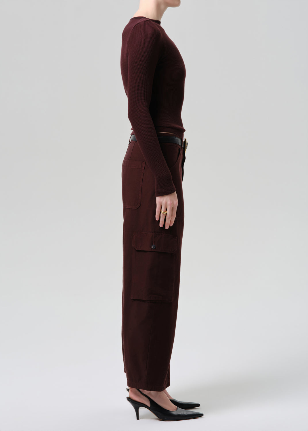 Person wearing a brown outfit with cargo pants on a grey background