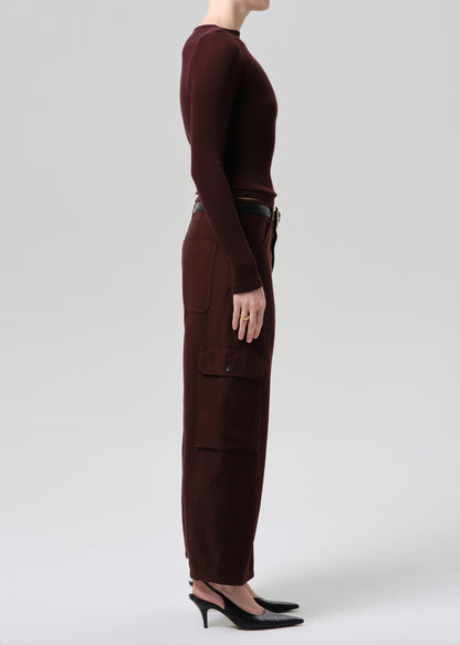 Person wearing a brown outfit with cargo pants on a grey background