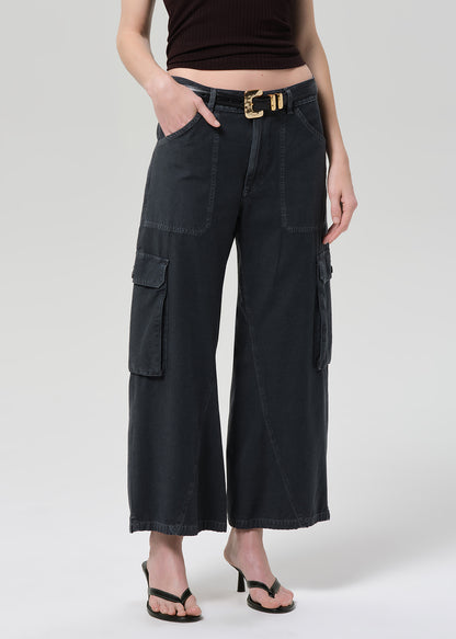 Person wearing a brown halter top and wide-leg cargo pants on a plain background