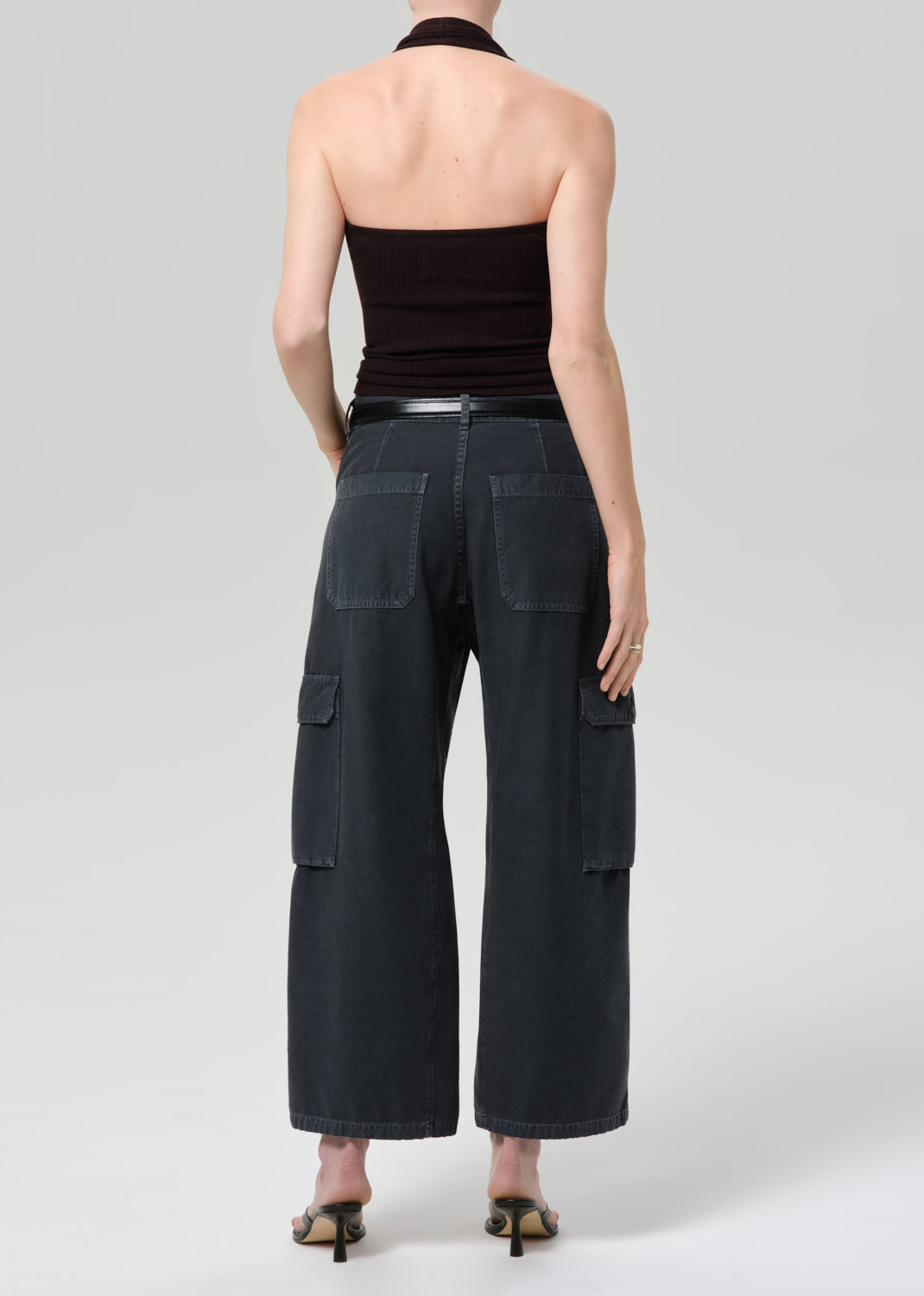 Person wearing a brown halter top and wide-leg cargo pants on a plain background