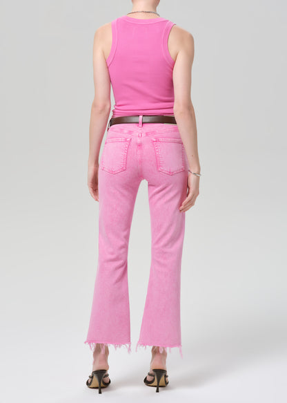 Person wearing a pink sleeveless top and pink jeans on a plain background