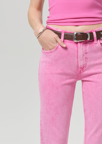 Person wearing a pink sleeveless top and pink jeans on a plain background