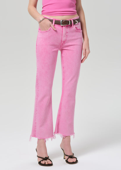 Person wearing a pink sleeveless top and pink jeans on a plain background