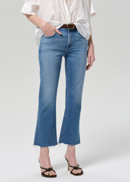 Person wearing light blue jeans and a white shirt on a plain background
