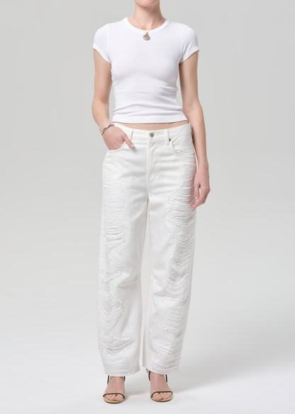 Person wearing a white t-shirt and white pants on a plain background