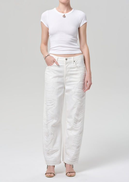 Person wearing a white t-shirt and white pants on a plain background