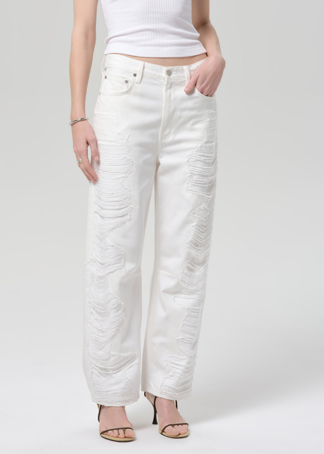 White jeans worn by a person on a plain background