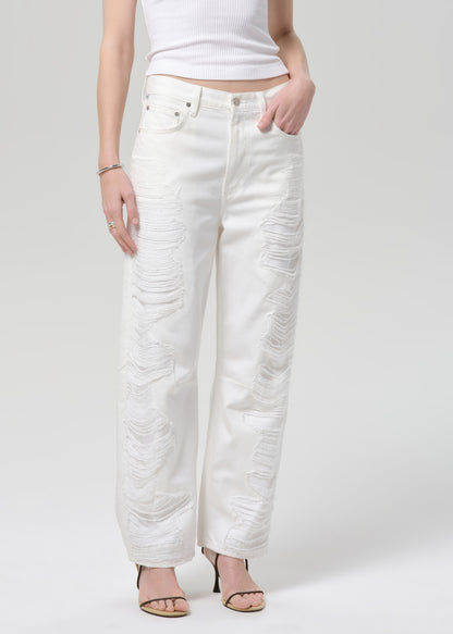 White jeans worn by a person on a plain background
