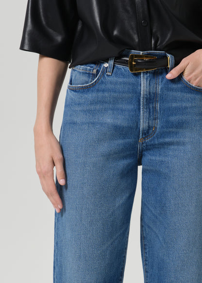 Close up of person wearing blue pants on a grey background