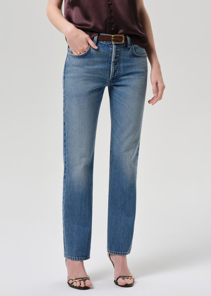 Person wearing blue jeans on a grey background
