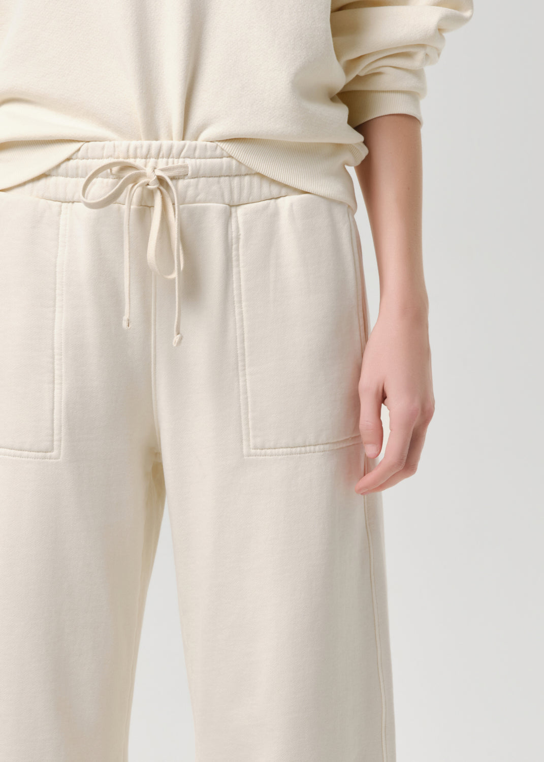 Beige pants with a drawstring waist on a grey background