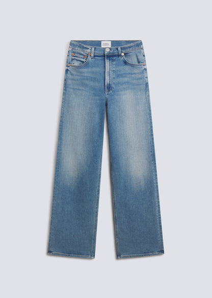 Palma Long in Celeste, featuring light blue denim with soft fading, a relaxed wide leg silhouette, classic five-pocket design, and full-length fit, front view on a grey background.