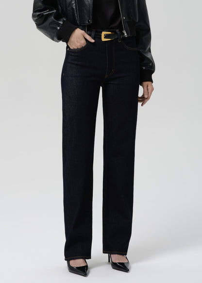 Person wearing black high-waisted jeans and a black leather jacket on a grey background