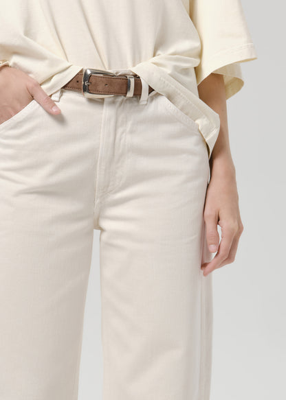 Close up of person wearing white pants on a grey background