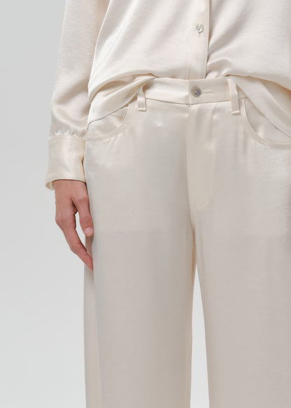 Close-up of ivory wide leg trousers on a grey background