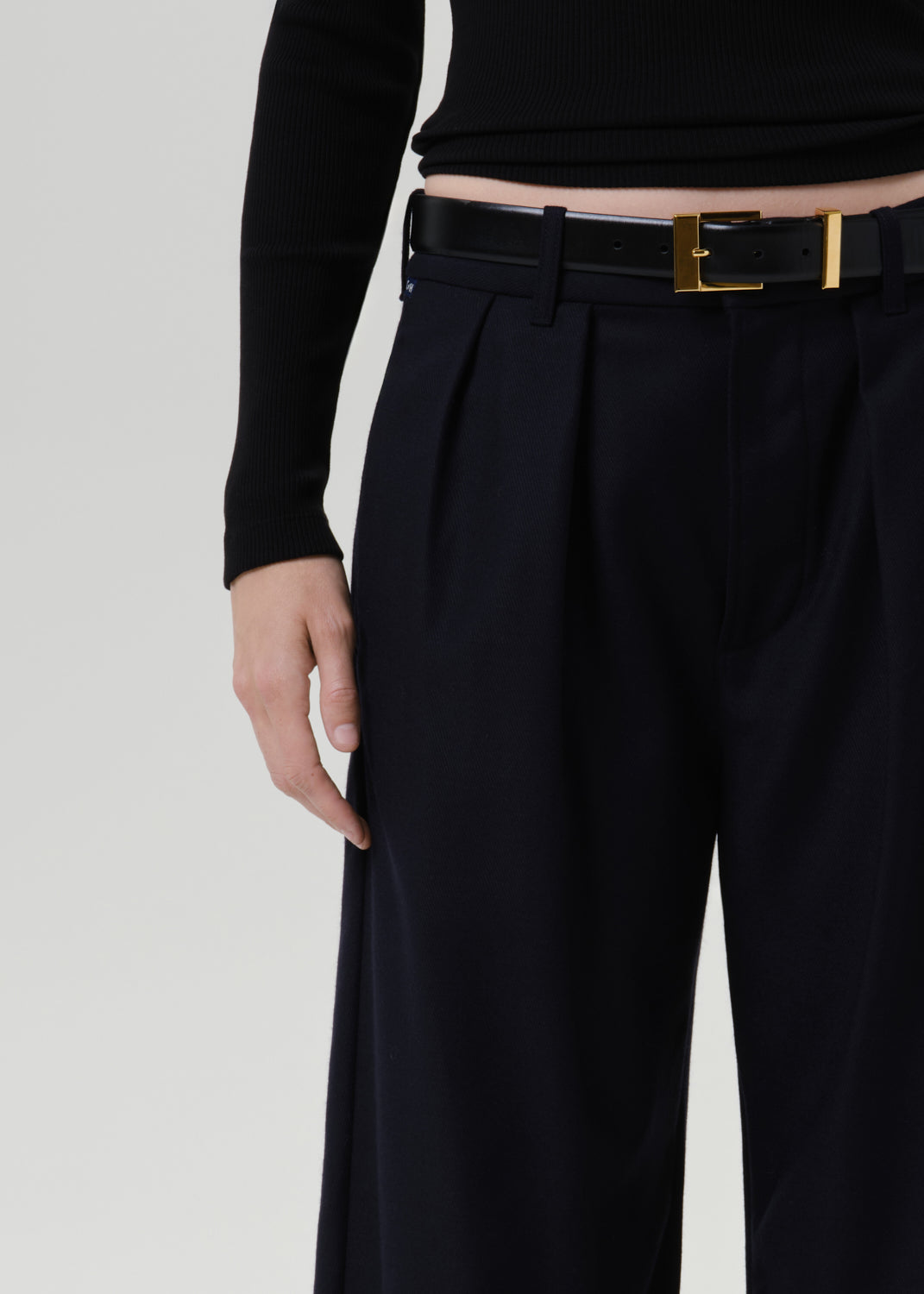 Close-up of dark navy wide leg trousers on a grey background