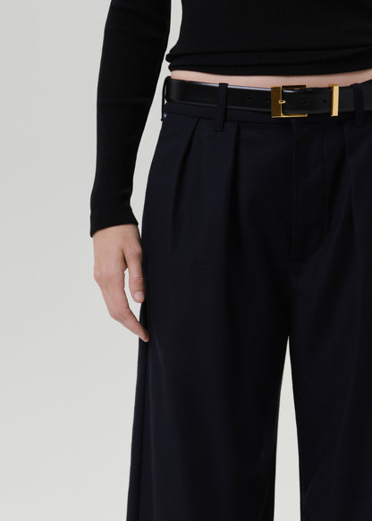 Close-up of dark navy wide leg trousers on a grey background