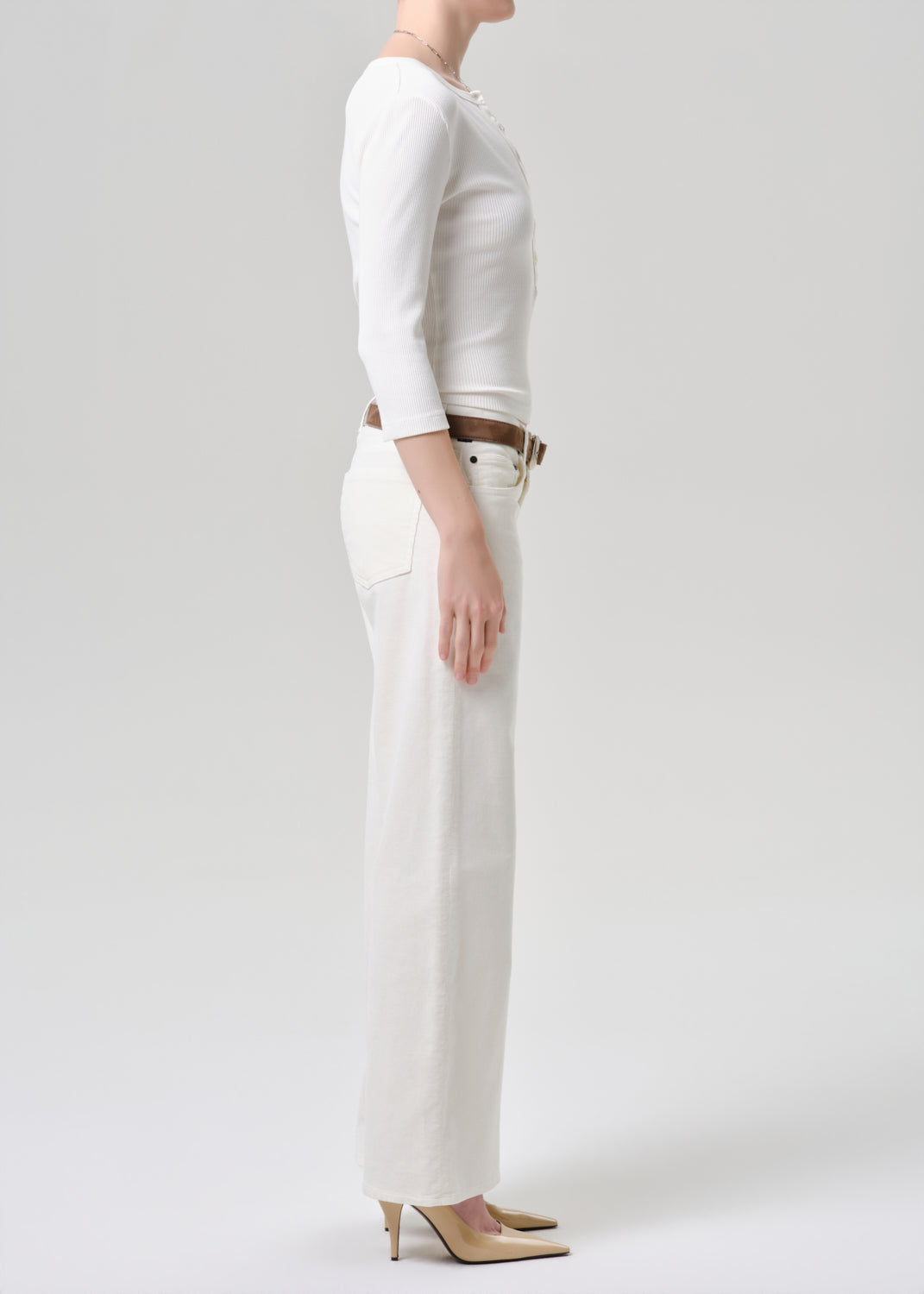 Person wearing a white outfit with a grey background
