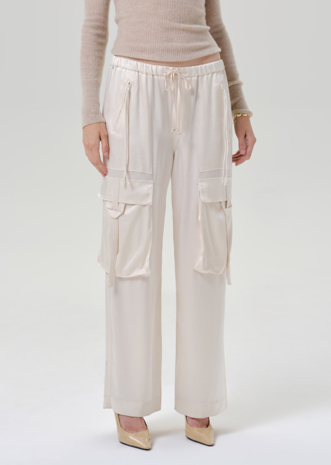 Person wearing white pants on a grey background
