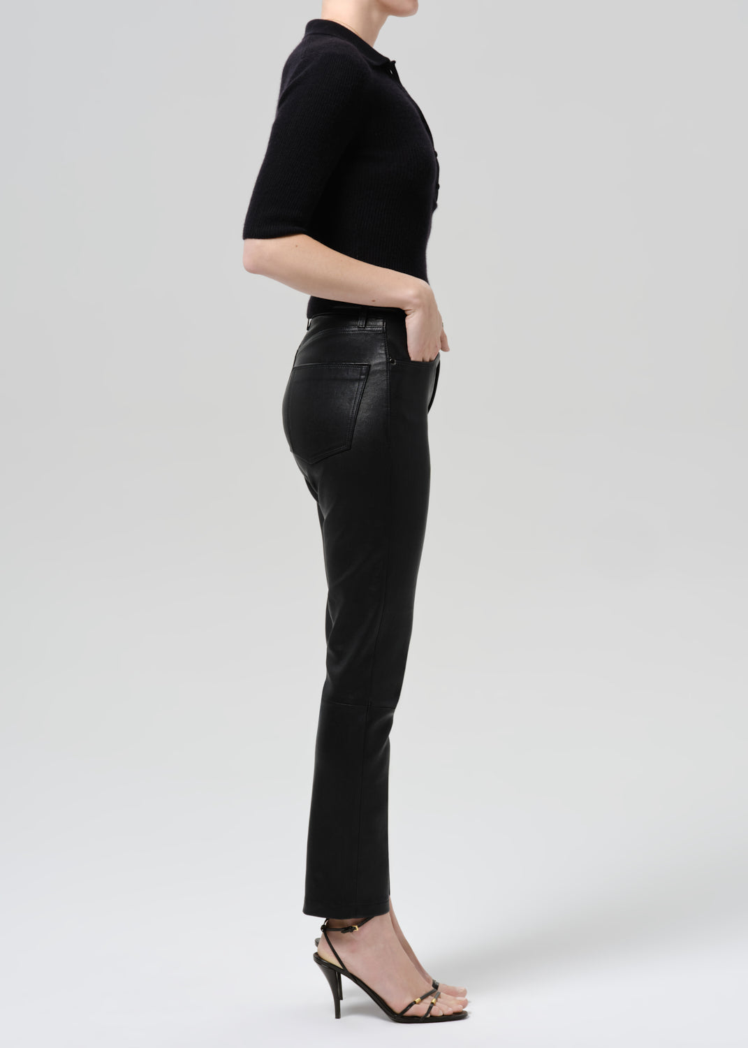 Person wearing black outfit on a grey background
