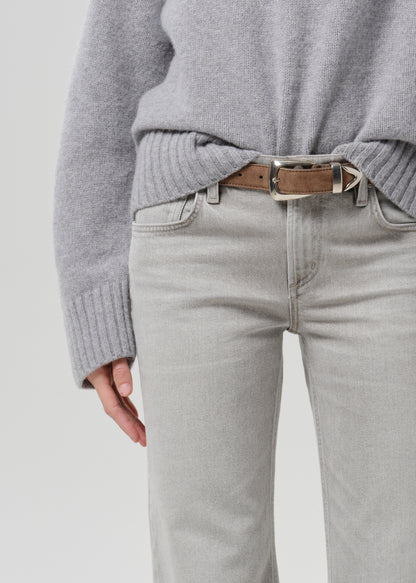 Close-up of light grey straight leg jeans on a grey background