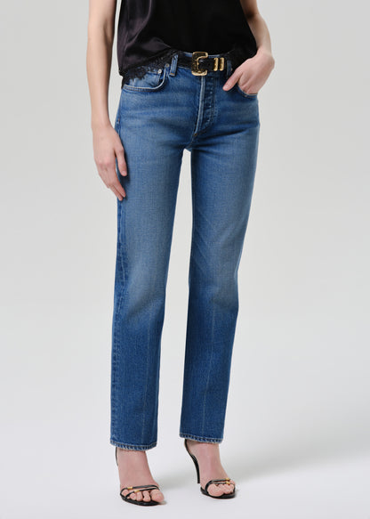 Person wearing blue jeans on a grey background