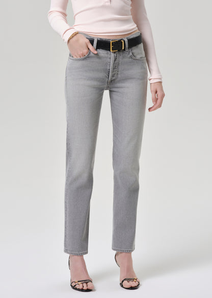 Person wearing light gray jeans with a grey background