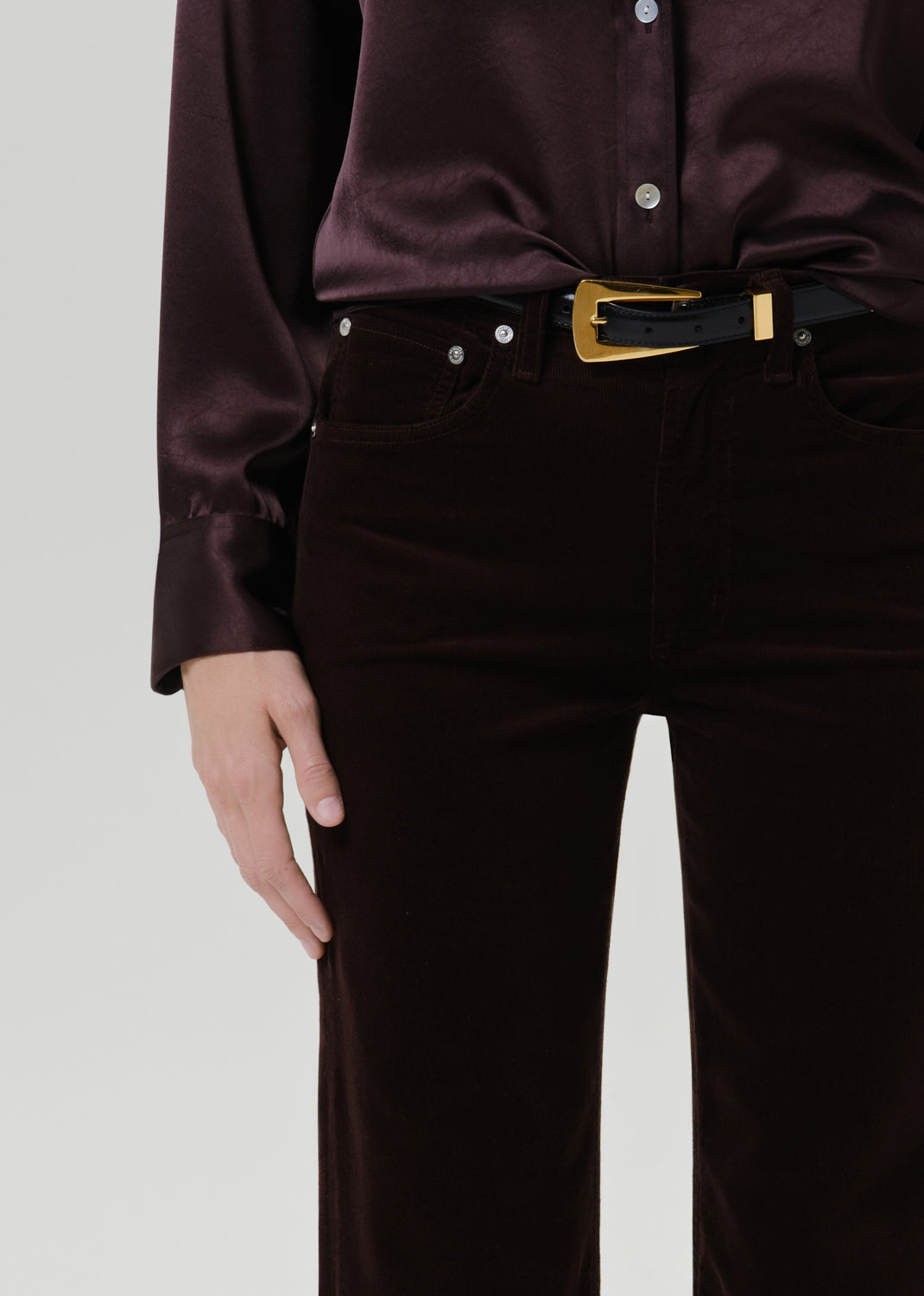 Close up shot of burgundy pants on a grey background
