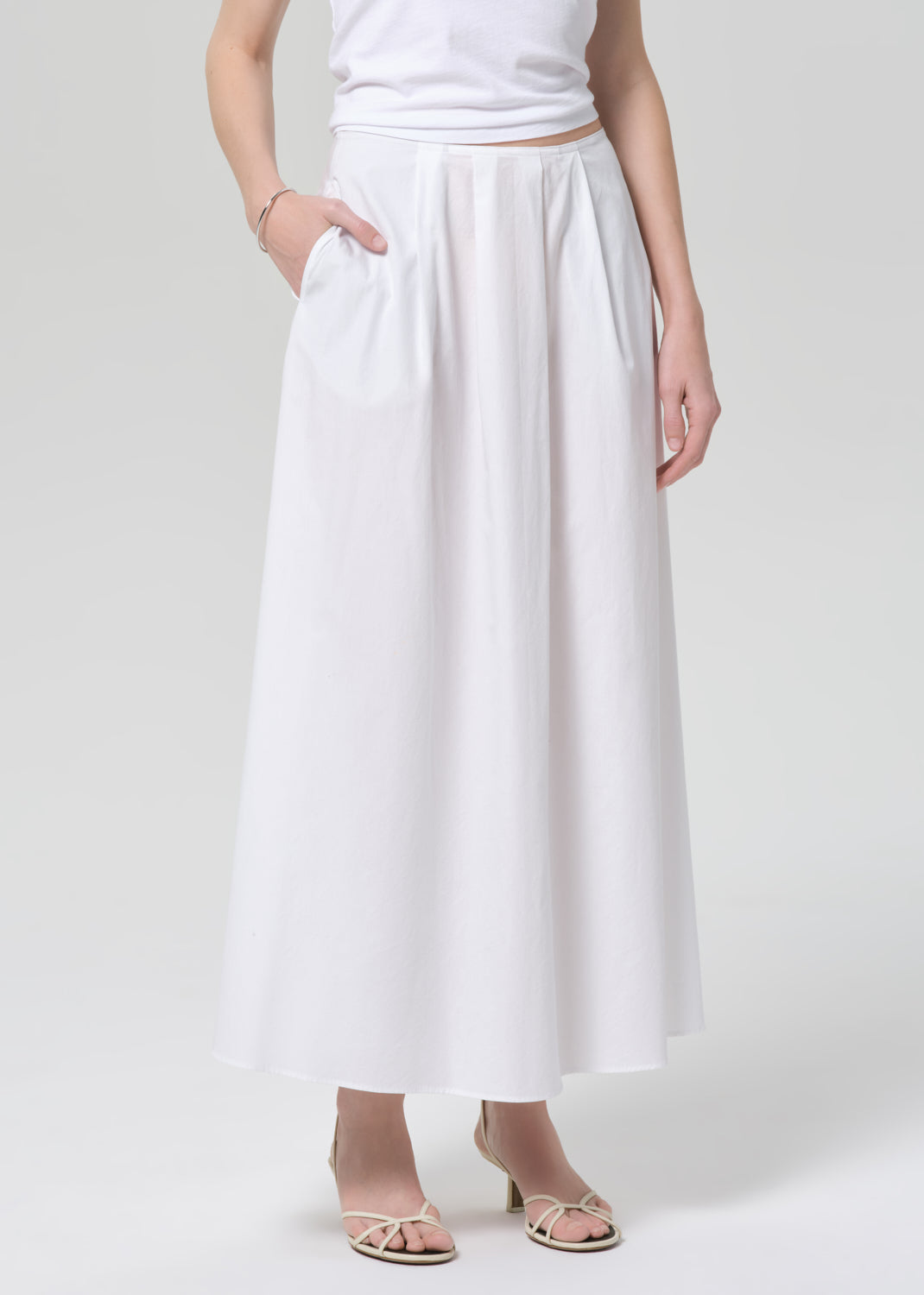 Person wearing a white skirt on a plain background
