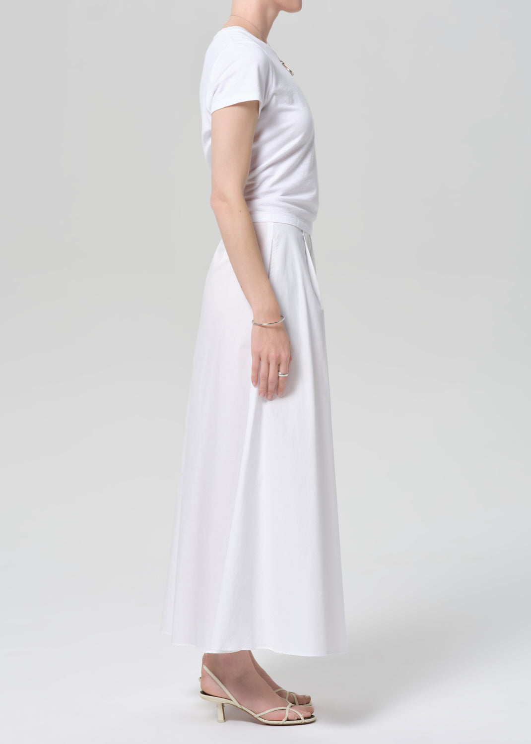 Person wearing a white dress on a plain background