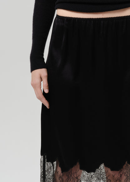 Close up of person wearing a black skirt on a grey background