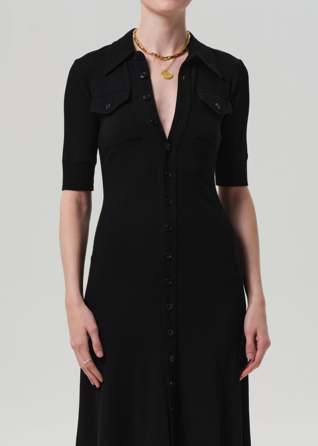 Black dress worn by a person on a grey background