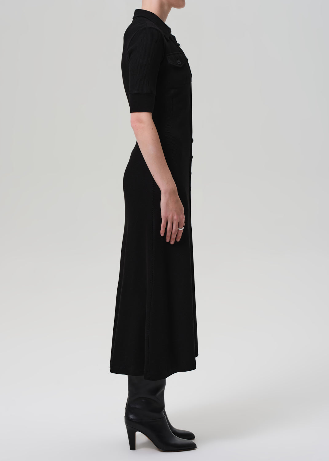 Black dress worn by a person on a grey background