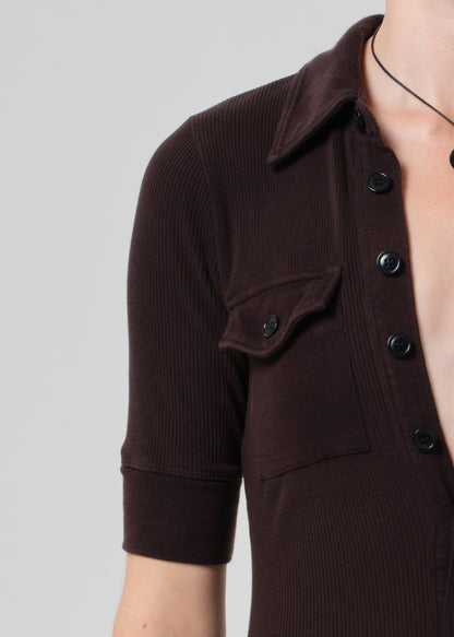 Woman wearing a brown dress on a grey background