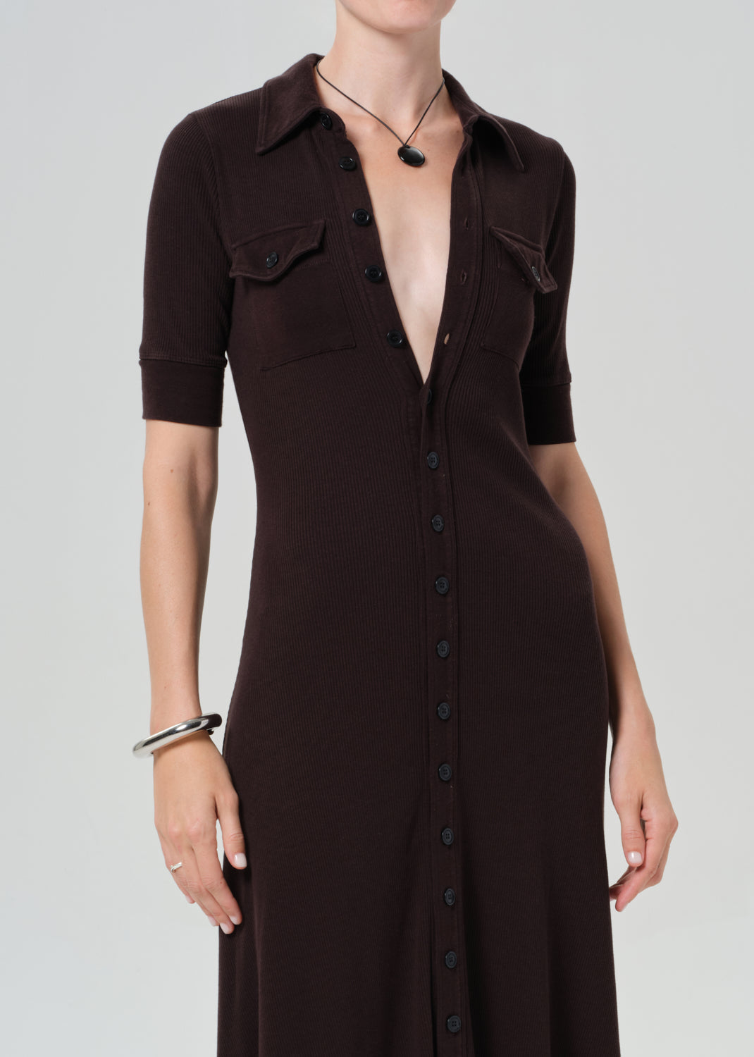 Woman wearing a brown dress on a grey background