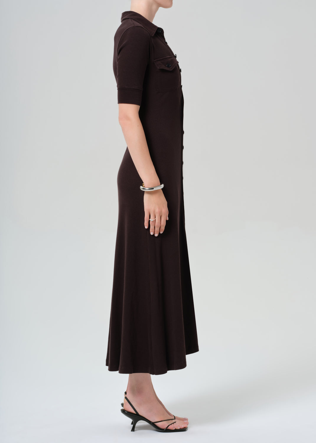 Woman wearing a brown dress on a grey background