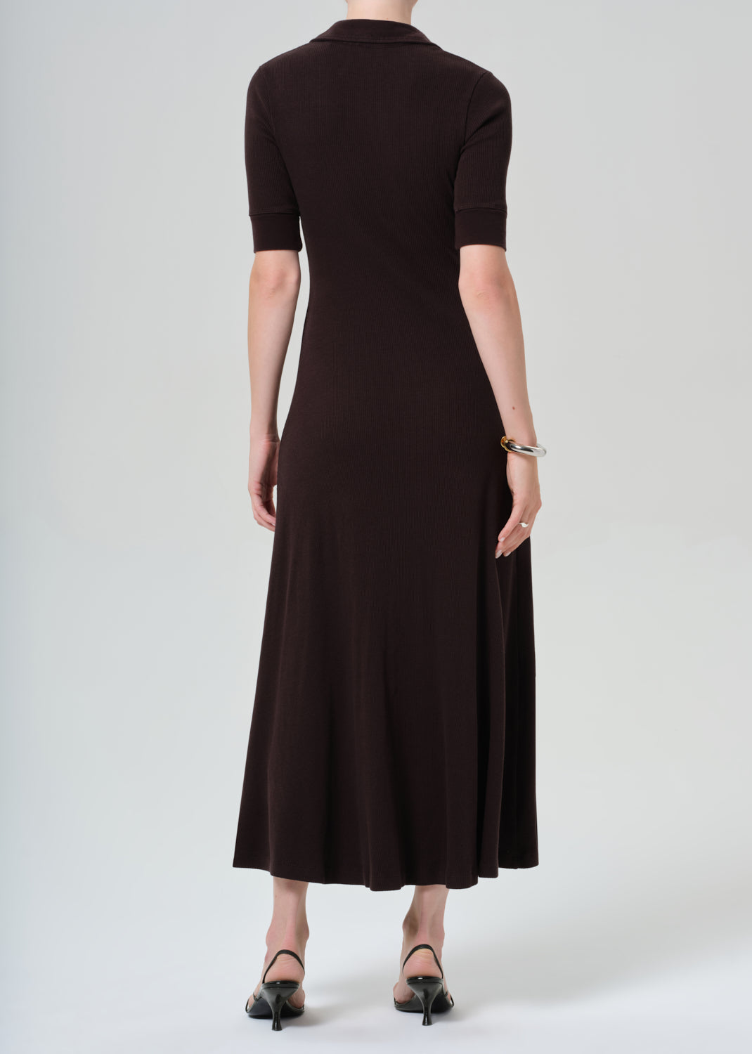 Woman wearing a brown dress on a grey background