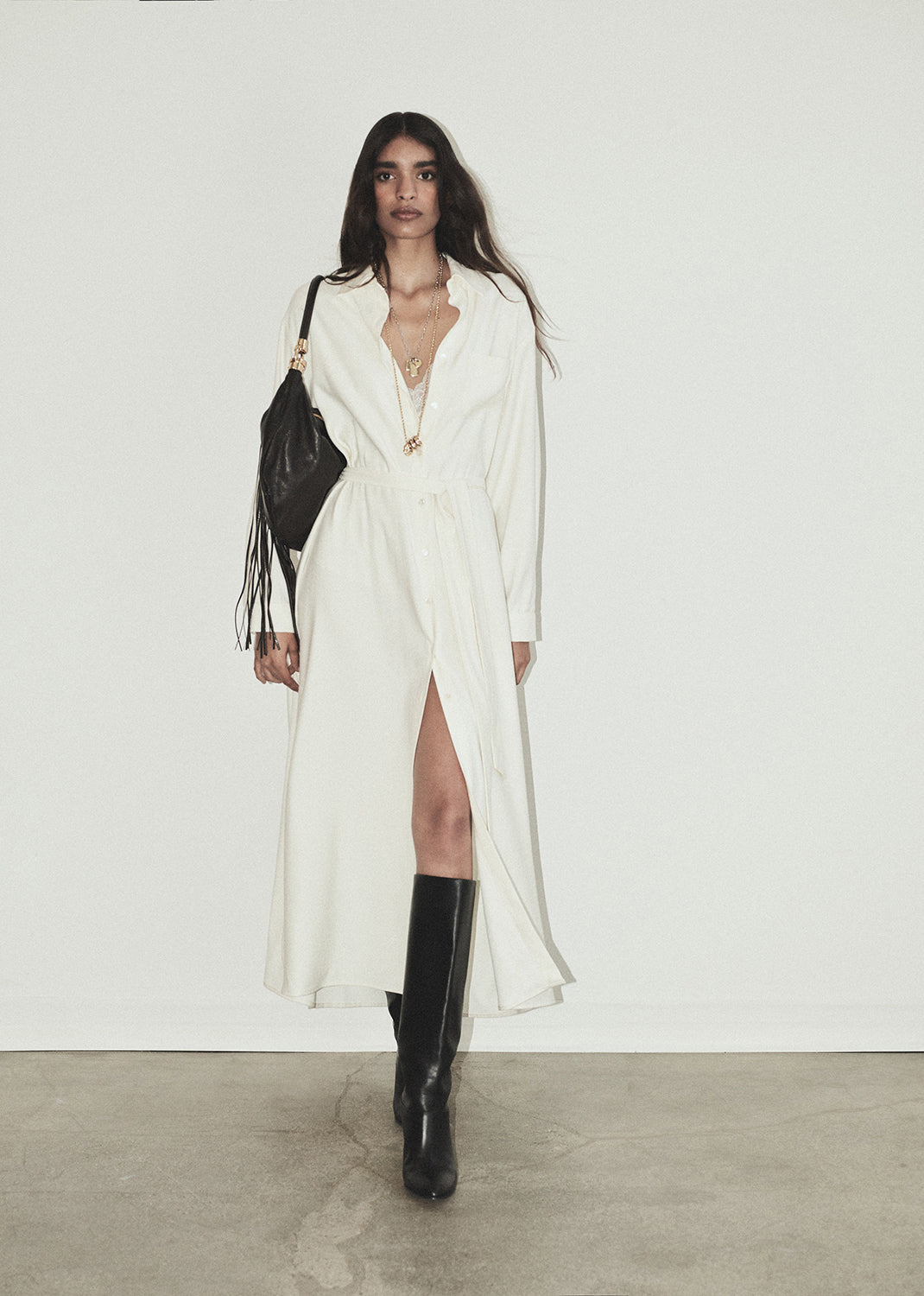 Person wearing a long white dress on a grey background